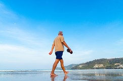 Middle aged man walking on a beach